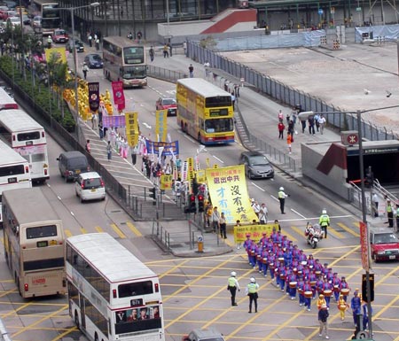 Парад шествует по Монкок, по обеим сторонам улицы стоят жители и туристы, которые наблюдают за грандиозным парадом. Фото: Цзинчао Пань/Великая Эпоха