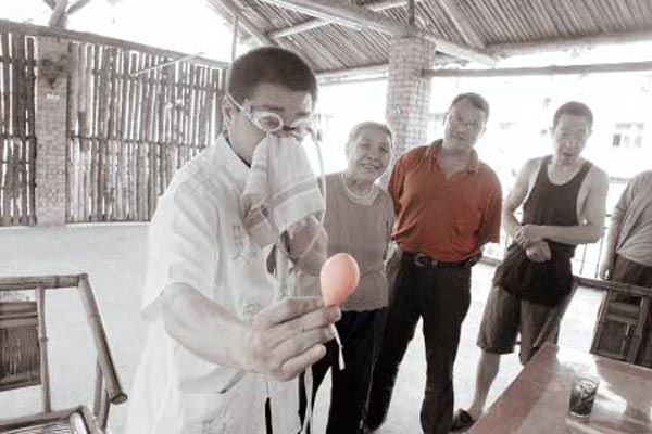 Чжан Цзюю глазом надувает воздушный шар. Фото с epochtimes.com Чжан Цзюю глазом надувает воздушный шар. Фото с epochtimes.com