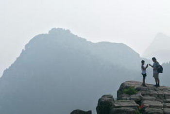Фото: Отец и сын перед горой Тайшань, самой знаменитой из пяти китайских священных гор даосизма в провинции Шаньдун. Frederic J. Brown/AFP/Getty Images