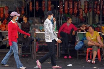 Люди в масках от инфекции свиного гриппа (H1N1). Фото: TANG CHHIN SOTHY/AFP/Getty Images
