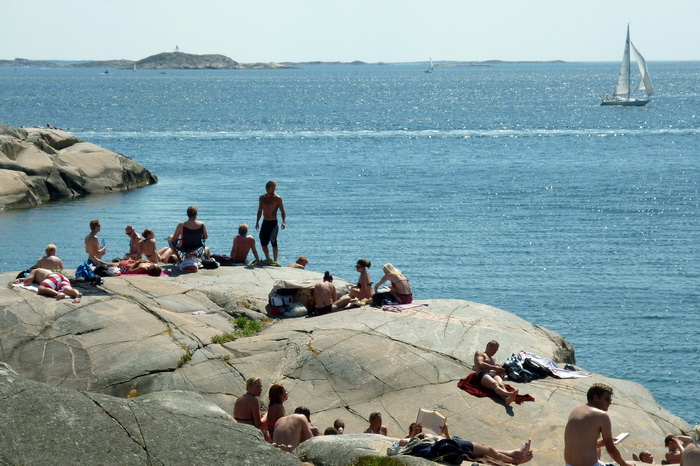 Люди загорают на скалах, Гётеборг, Швеция. Фото: OLIVIER MORIN/AFP/Getty Images