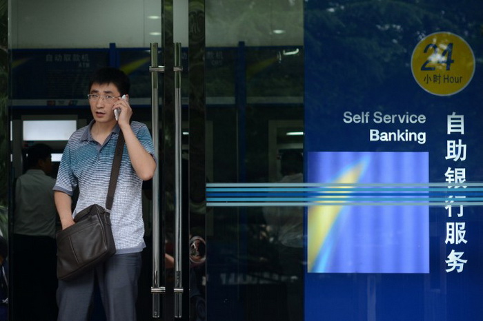 Клиент разговаривает по мобильному телефону у входа в банк в Пекине, 25 июня 2013 года. Фото: Wang Zhao AFP/Getty Images Клиент разговаривает по мобильному телефону у входа в банк в Пекине, 25 июня 2013 года. Фото: Wang Zhao AFP/Getty Images