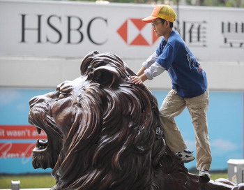 Мальчик играется на одном из двух львов, охранявших штаб-квартиру банка HSBC в Центральном районе Гонконга. Фото: MIKE CLARKE/AFP/Getty Images Мальчик играется на одном из двух львов, охранявших штаб-квартиру банка HSBC в Центральном районе Гонконга. Фото: MIKE CLARKE/AFP/Getty Images