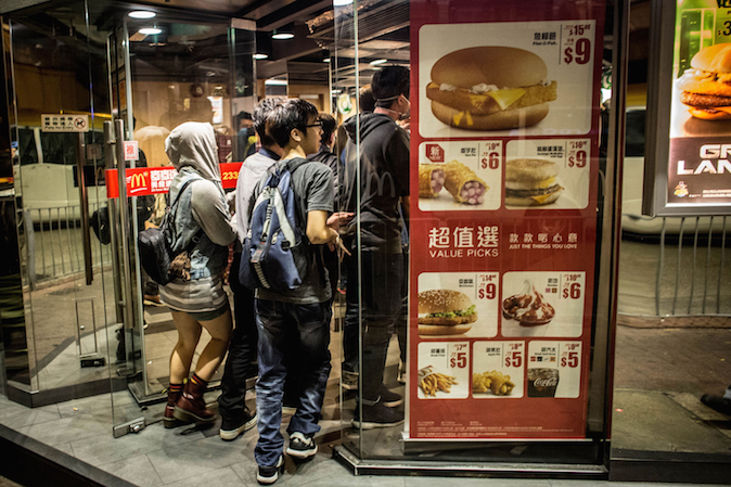 Продемократические активисты убегают от полиции в магазин McDonalds на улице в Монгкоке 29 ноября 2014 года, Гонконг. Хотя полиция зачистила места протестов, столкновения с демократическими активистами в районе Монгкок продолжаются. Фото: Chris McGrath/Getty Images | Epoch Times Россия