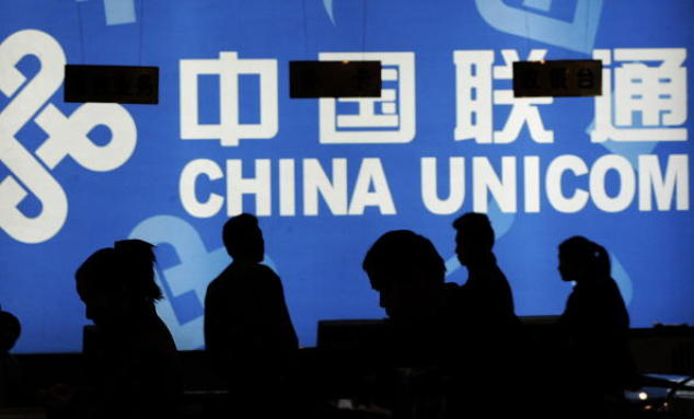 Клиенты смотрят на продукты China Unicom в телекоммуникационном магазине в Пекине 9 ноября 2004 года. Из-за внутренней борьбы за власть были арестованы том-менеджеры этой крупной компании мобильной связи. Фото: Peter PARKS/AFP/Getty Images