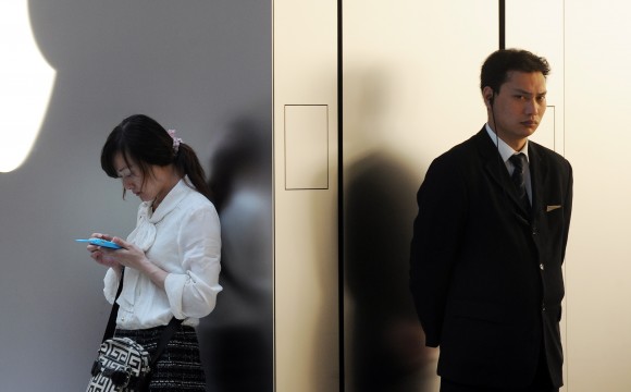 Женщина говорит по мобильному телефону у магазина Apple в Шанхае, 7 мая 2012 г. Фото: PETER PARKS/AFP/Getty Images Женщина говорит по мобильному телефону у магазина Apple в Шанхае, 7 мая 2012 г. Фото: PETER PARKS/AFP/Getty Images