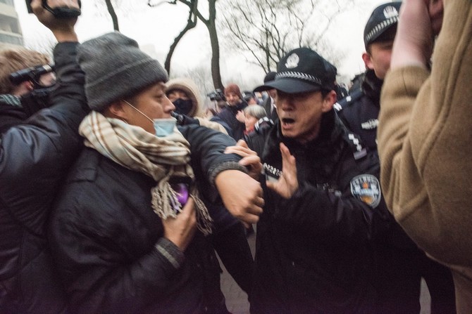 Милиционер отталкивает журналистов и сторонников правозащитника Пу Чжицяна у здания второго народного суда в Пекине 14 декабря 2015 г. Фото: FRED DUFOUR/AFP/Getty Images