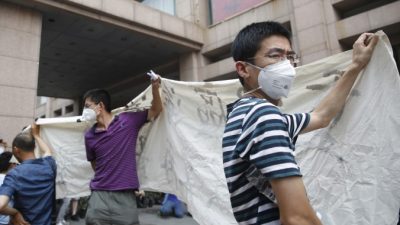 Пикет владельцев домов, разрушенных взрывом в Тяньцзине, во время пресс-конференции местных властей, 17 августа 2015 г., Тяньцзинь. Фото: STR/AFP/Getty Images