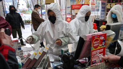 Работники аптек в защитной одежде и масках обслуживают клиентов в Ухане 25 января 2020 года. HECTOR RETAMAL/AFP via Getty Images