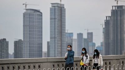 Люди в масках идут по мосту через реку Янцзы, Ухань, провинция Хубэй, 1 апреля 2020 года HECTOR RETAMAL/AFP via Getty Images