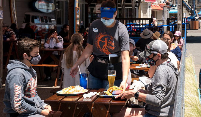 Посетители в масках сидят на открытом патио ресторана в Сан-Франциско. David Paul Morris/Bloomberg via Getty Images | Epoch Times Россия