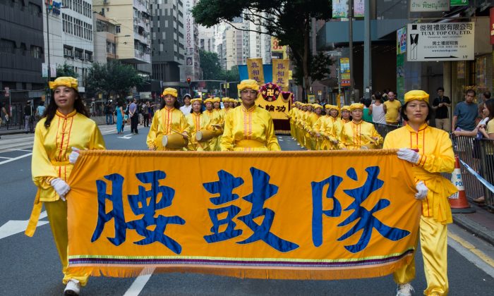 Последователи Фалуньгун вместе с людьми из глобального центра по выходу из Китайской партии маршируют на параде по улицам Гонконга в знак протеста против Национального дня Китая 1 октября 2014 г. (Бенджамин Честин / Epoch Times) | Epoch Times Россия