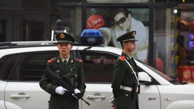 Китайские полицейские наблюдают за пешеходами в торговом районе Ванфуцзин в Пекине 24 октября 2014 г. (Greg Baker / AFP / Getty Images)