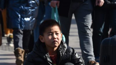 Мальчик с родителями ждет у железнодорожного вокзала Пекина 17 февраля 2015 года. Сотни миллионов китайцев возвращаются в свои родные города, чтобы отпраздновать лунный Новый год, который начинается 19 февраля, с семьями, которые являются крупнейшей ежегодной миграцией в мире. . (Грег Бейкер / AFP / Getty Images)