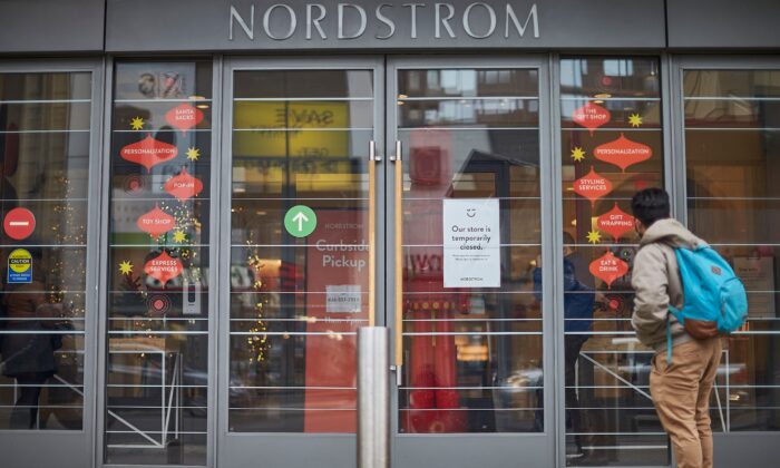Мужчина стоит перед закрытым магазином Nordstrom в центре Торонто, Канада, 23 ноября 2020 года