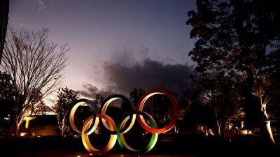 Олимпийские кольца видны рядом с Национальным стадионом, основным местом проведения Олимпийских и Паралимпийских игр в Токио в 2020 году, Токио, 8 января 2021 года. BEHROUZ MEHRI/AFP via Getty Images