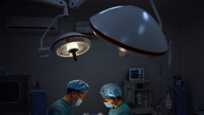 Пластический хирург выполняет «особую» операцию на носу пациенту в своей клинике, Чунцин, Китай, 9 августа 2013 года. PETER PARKS/AFP via Getty Images