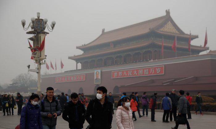 Китайские туристы в масках на площади Тяньаньмэнь во время сильного загрязнения 25 февраля 2014 года в Пекине, Китай. (Линтао Чжан / Getty Images) | Epoch Times Россия
