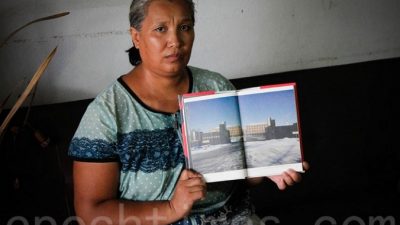 Последовательница Фалуньгун Инь Липин показывает фотографию исправительного лагеря, в котором она подвергалась репрессиям. Фото: The Epoch Times