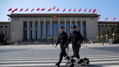 Два полицейских с собаками охраняют фасад Большого зала народных собраний в Пекине 13 марта 2015 г. (Lintao Zhang / Getty Images)