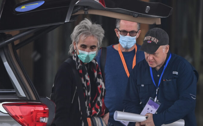 Члены группы ВОЗ Питер Дашак (справа) и Марион Купманс (слева) в сопровождении Питера Бен Эмбарека (в центре) покидают свой отель в Ухане, городе в провинции Хубэй в центральном Китае, 10 февраля 2021 г. | Epoch Times Россия