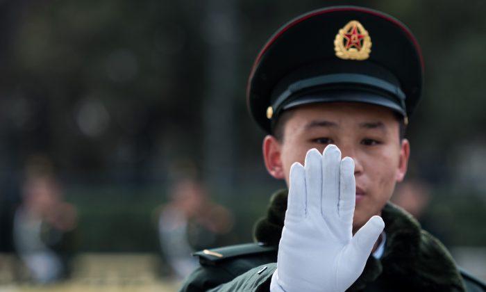 Охранник перед Большим залом народных собраний в Пекине во второй день Всекитайского собрания народных представителей 6 марта. (Johannes Eisele / AFP / Getty Images)