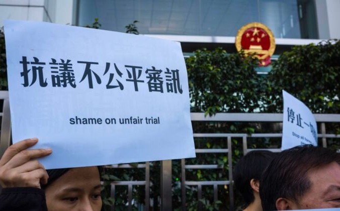 Активисты держат плакаты в поддержку задержанного китайского адвоката по правам человека на митинге у китайского офиса в Гонконге 26 декабря 2018 г. Anthony Wallace/AFP via Getty Images