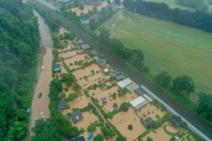 Снимок с воздуха сделан 14 июля 2021 года показывает затопленную дорогу, дома и поля в Хагене  Германии. Проливной дождь обрушился на запад страны, вызвав масштабное наводнение. INA FASSBENDER / AFP via Getty Images | Epoch Times Россия