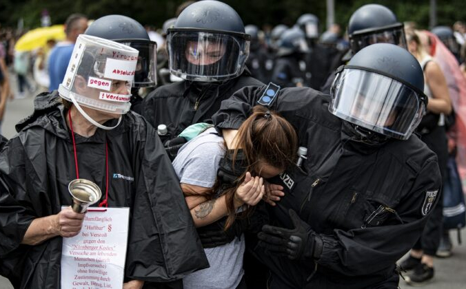 Полиция арестовывает протестующую девушку во время демонстрации против мер по борьбе с COVID-19 у Колонны Победы в Берлине 1 августа 2021 г. Fabian Sommer / dpa via AP | Epoch Times Россия