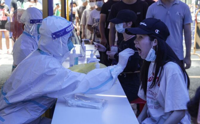 Женщина проходит тест на нуклеиновую кислоту на вирус COVID-19 в Гуанчжоу, Китай, 30 мая 2021 г. (AFP via Getty Images) | Epoch Times Россия