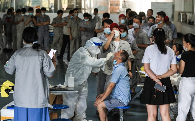 Рабочий проходит тест на COVID-19 в столовой завода по производству автомобильных запчастей в Ухане, провинция Хубэй в центральном Китае, 4 августа 2021 г. (STR/AFP via Getty Images) | Epoch Times Россия