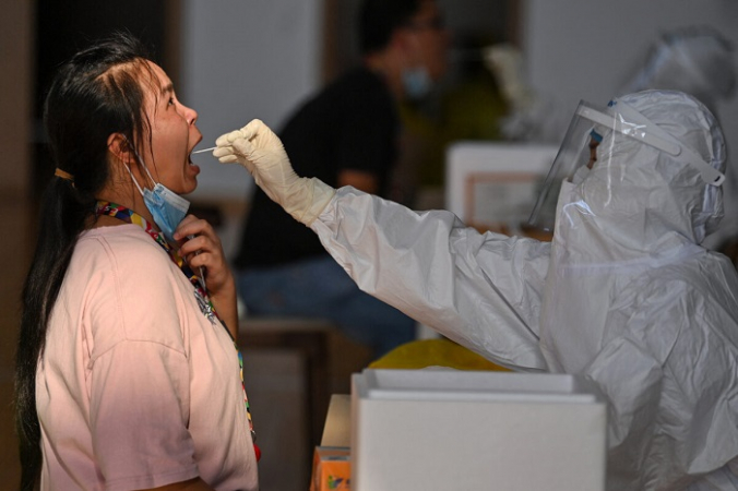 Сотрудник спортзала проходит тестирование на COVID-19 в Ухане, провинция Хубэй в центральном Китае, 5 августа 2021 г. (STR/AFP via Getty Images) | Epoch Times Россия