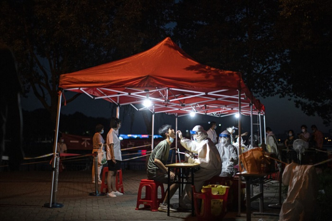 Медицинский работник берёт образцы во время массового тестирования на COVID-19 в жилом квартале в Ухане, провинция Хубэй, Китай, 6 августа 2021 года (Getty Images) | Epoch Times Россия