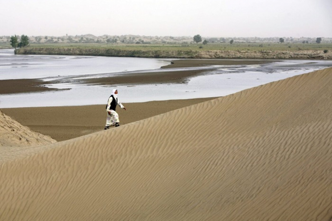 Житель Кежиянь гуляет по песчаным дюнам вдоль реки Кежиянь в деревне Дахэянь в уезде Юйтянь провинции Синьцзян, Китай, 10 сентября 2007 г. (China Photos / Getty Images) | Epoch Times Россия
