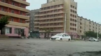 Автомобили проезжают по затопленным улицам после проливных дождей в провинции Хамгён-Намдо в Северной Корее. (KRT via APTV)