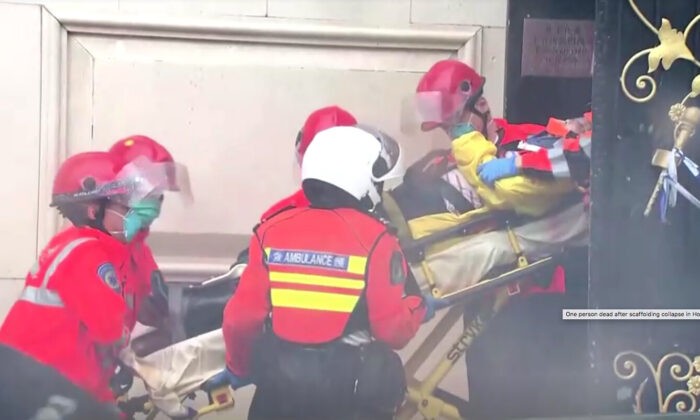 Сотрудники службы экстренной помощи выносят человека на носилках из здания в Гонконге, 8 октября 2012 г. Screenshot via NTD/TVB via Reuters | Epoch Times Россия