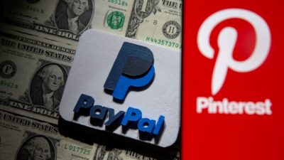 Логотип Pinterest на смартфоне, размещённом над долларовыми банкнотами США, и напечатанный на 3D-принтере логотип PayPal на этой иллюстрации, сделанной 20 октября 2021 г. Dado Ruvic / Illustration / Reuters