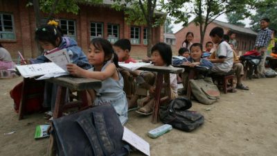 Дети учатся на открытом воздухе в начальной школе в сельской местности 22 мая 2007 года в уезде Хусянь провинции Шэньси, Китай. Занятия проводятся на открытом воздухе в целях безопасности, так как здание школы находится под угрозой обрушения. В некоторых сельских районах Китая система образования по-прежнему сталкивается с нехваткой финансирования, хороших учителей и стабильных условий. (Photo by China Photos/Getty Images)