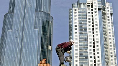 Репрессивные меры коммунистического правительства в отношении бизнеса и магнатов изменили рейтинг самых богатых людей Китая. На снимке: строитель кладёт кирпичи возле высотных домов в Шанхае, 31 марта 2005 г. AFP PHOTO / LIU Jin