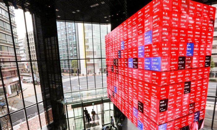 Люди проходят под электронной доской в конференц-зале в Токио, Япония, 1 ноября 2021 г. Koji Sasahara/AP Photo | Epoch Times Россия