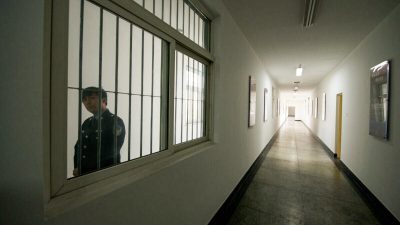 Охранник смотрит в окно коридора в Центре содержания под стражей № 1 в Пекине 25 октября 2012 года. AFP PHOTO / Ed Jones (Photo credit should read Ed Jones/AFP via Getty Images)
