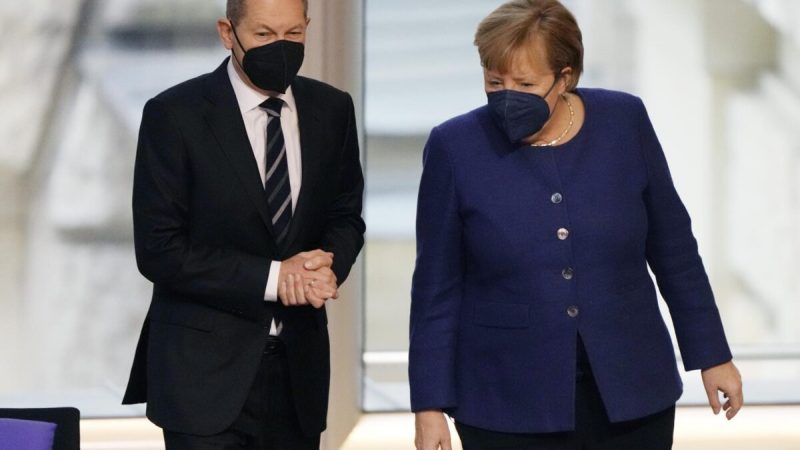 Канцлер Германии Ангела Меркель (справа) и кандидат в канцлеры от СДПГ Олаф Шольц разговаривают во время заседания Бундестага о новых мерах COVID-19 в здании Рейхстага в Берлине 18 ноября 2021 года. (Markus Schreiber/AP Photo) 