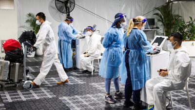 Пассажиры проходят тесты на COVID-19 в центре тестирования перед вылетом возле международного терминала в аэропорту Сиднея в Австралии, 29 ноября 2021 года. (Loren Elliott/Reuters)