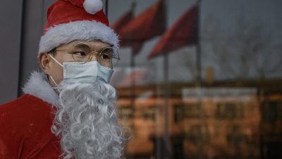 Китаец в костюме Санта-Клауса приветствует клиентов на рождественском мероприятии в торговом центре в Пекине 24 декабря 2020 г. Фото: Kevin Frayer, Getty Images
