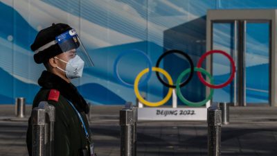 Полицейский стоит на страже внутри замкнутого пузыря для зимних Олимпийских игр 2022 года в Пекине возле главного медиацентра в Олимпийском парке в Пекине, 29 января 2022 года. (Kevin Frayer/Getty Images) 