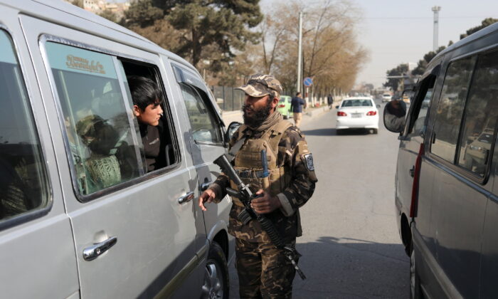 Боец Талибана* обыскивает автомобиль во время охраны контрольно-пропускного пункта в Кабуле, Афганистан, 27 ноября 2021 года. (AliKhara/Reuters) | Epoch Times Россия