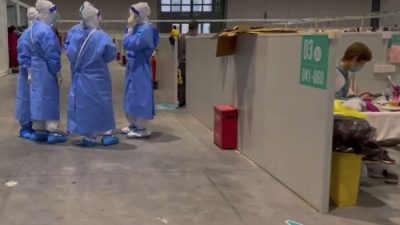 Медицинские работники общаются в Национальном выставочном и конференц-центре в Шанхае 15 апреля 2022 года. (Beibei via AP)