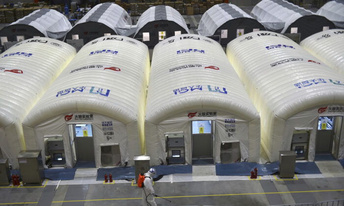 Дезинфекция возле надувных кабин во всплывающей лаборатории Хуо-Янь для тестирования образцов на вирус COVID-19 в Нанкине, провинция Цзянсу, Восточный Китай, 28 июля 2021 года. Фото: Chinatopix/Via AP
