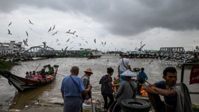 Люди садятся на паром на реке Янгон в Янгоне 22 марта 2022 года. (AFP via Getty Images)
