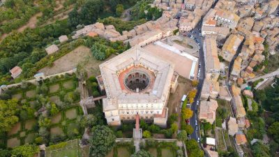  Главная дорога ведёт к пятиугольной вилле Фарнезе. Внутри виден круглый двор, а разводные мосты слева ведут через ров к партерному саду эпохи Ворзрождения. Для партерных садов характерны живые изгороди геометрической формы, предназначенные для просмотра из здания. (AerialDronePics/Shutterstock)